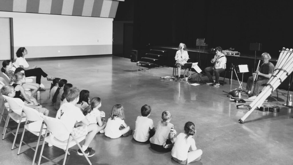 Les artistes du groupe Le Caméléon zébré font un extrait de leur spectacle musical devant les enfants du centre de loisirs, à la salle multiculturelle de Técou.